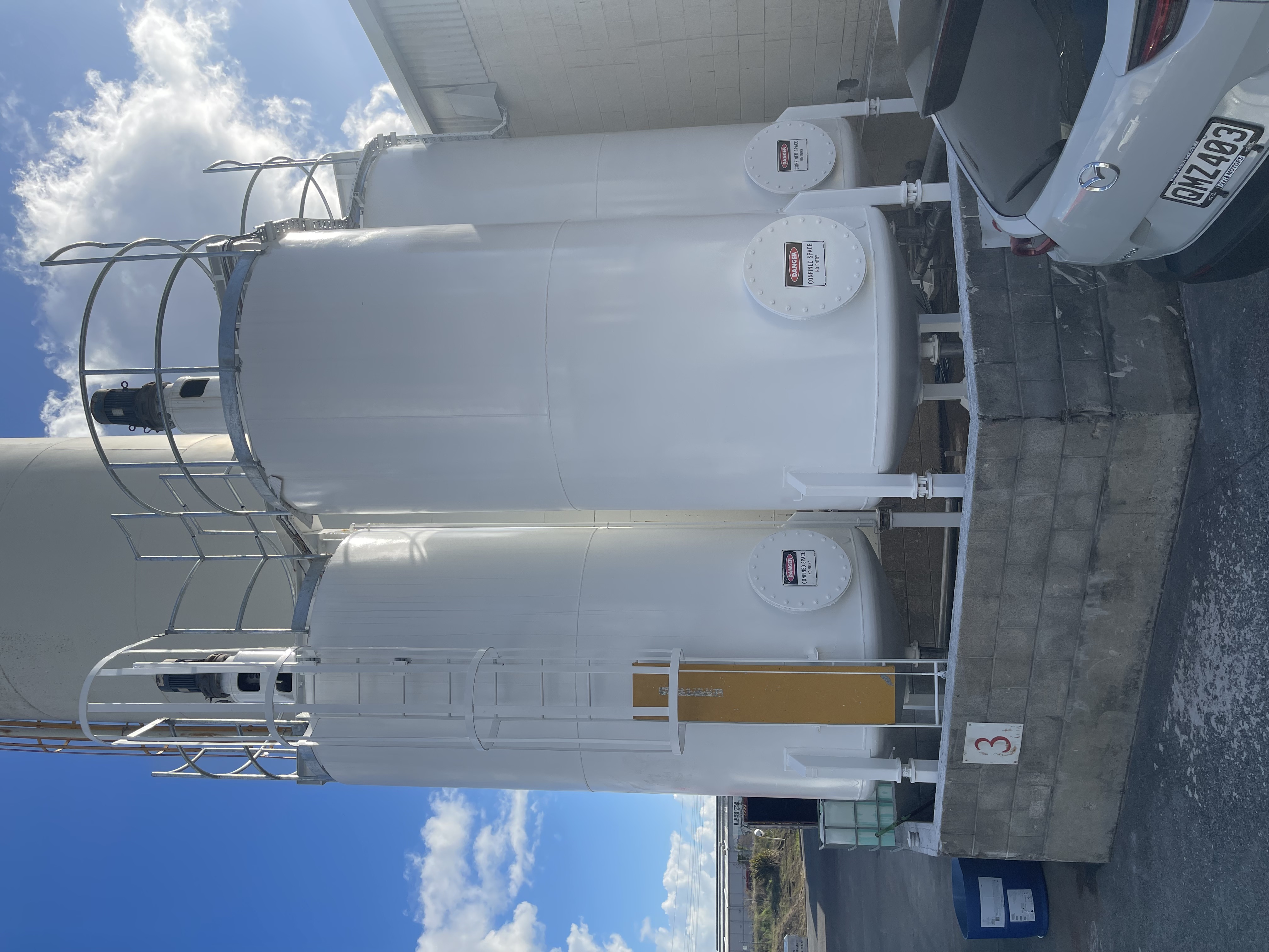 Restored industrial tanks with completed white protective coating