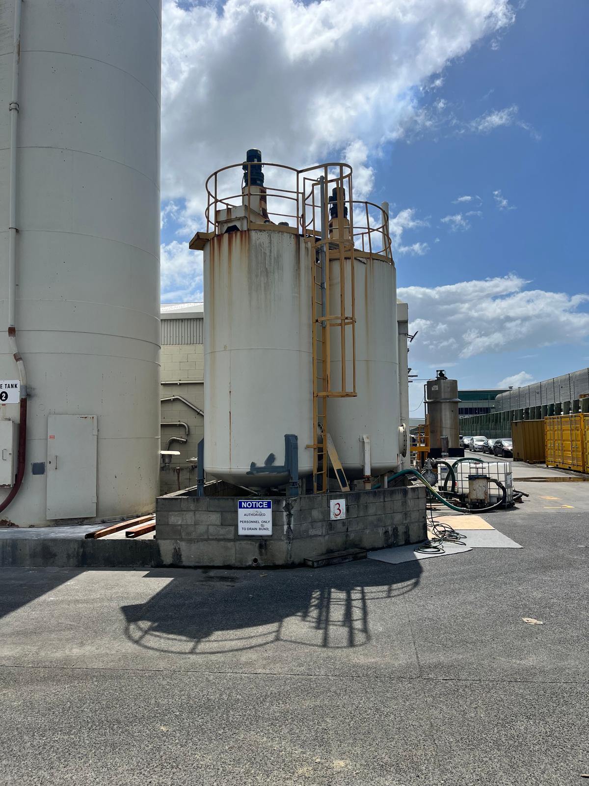 Industrial tank with visible weathering and failed coating before restoration